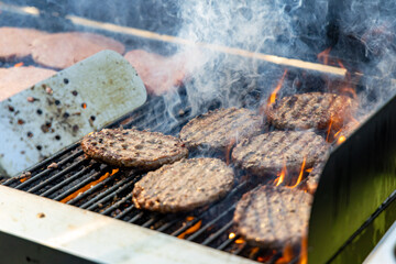 grilling burgers with open fire, meat on the grill