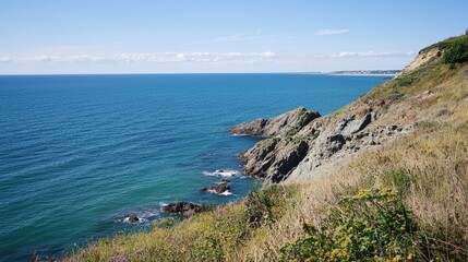 Fototapeta premium Serene coastal view over tranquil waters at a sunny day overlooking rocky cliffs