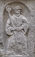Religious figure with a staff carved on stone. Prophet. Ancient architecture. Religious studies.