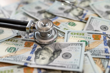  stethoscope on dollar banknotes as premium medical insurance concept. No people