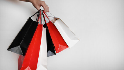 A person holding colorful shopping bags signifies Black Friday consumerism and holiday shopping excitement