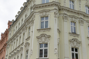 A large white building, featuring numerous windows, is situated prominently on the corner of the bustling street, catching the eye of passersby