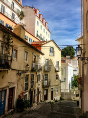A picturesque view of a narrow, sunlit street in Lisbon with traditional European architecture, perfect for travel and exploration concepts