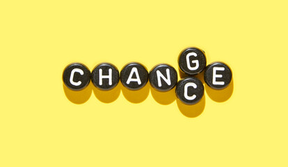 Inspirational concept of change word with letter tiles on vibrant yellow background for...