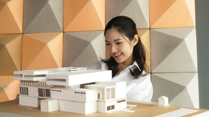 Skilled attractive architect engineer holds architect model while checking mistake point carefully....