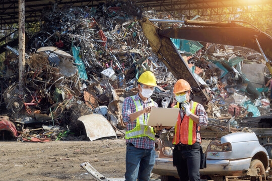 Two workers looking at a laptop in a recycling centre, Thailand