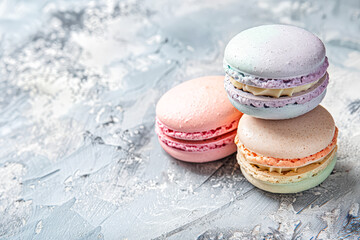 Obraz premium Three colorful macarons stacked on top of each other on a grey background