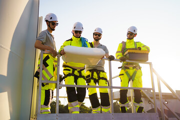 Fototapeta premium Team of electrical engineer is perform the inspection and maintenance of electric generating windmill turbine.