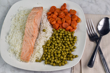 baked salmon on rice with  peas and carrots