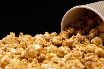 Sweet caramelized popcorn spilled out of the glass.