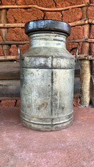 Old iron container for transporting fresh milk on a rustic background.