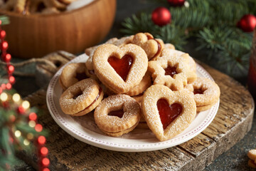 Traditonal Linzer Christmas cookies on a white plate with spruce tree branches and decoration