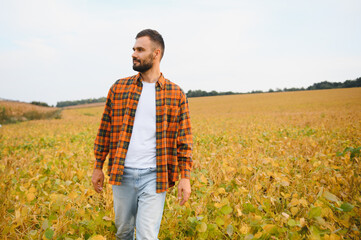 Farmer, agronomist in the soybean field. Controlling the growth of agricultural crops