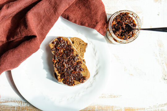 Overhead view of two slices of Rye sourdough bread with a jar of traditional Georgian spicy adjika