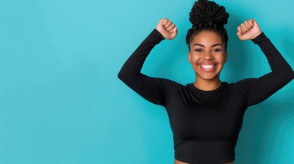 Joyful woman in black long sleeve crop top celebrating against blue background
