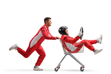 Young car racer running and pushing a mature car racer inside a shopping cart