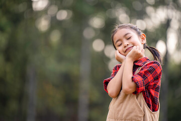 A little girl is walking in the garden and breathing in the fresh air.