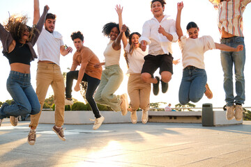 Eight young people are jumping in the air together outdoors