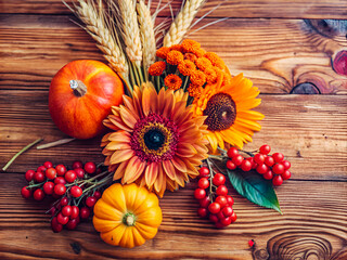Fototapeta premium Autumn background with orange and yellow gerbera on a wooden table