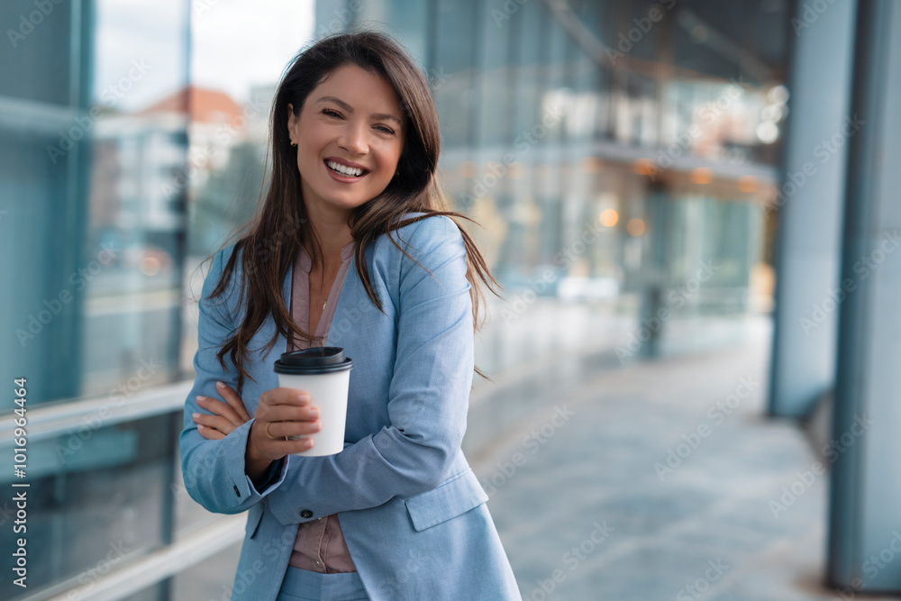 Wall mural Portrait of happy businesswoman walking outdoor and holding cup of coffee