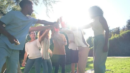 Friends celebrating outdoors, raising drinks under the sun. Laughter and joy in a lush park, creating memorable moments together