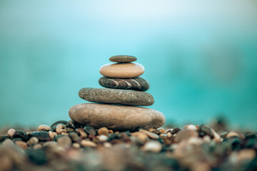 A pyramid of stones on a pebble beach by the sea, the concept of balance, calm, tranquility, relaxation with copy space