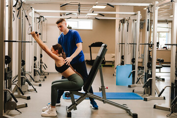 Spine rehabilitation with kinesiotherapy. Doctor helps his patient to relax tense back muscles and...