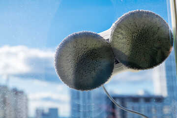 Robot window cleaner washes glass with round rags, robotic service, modern technologies