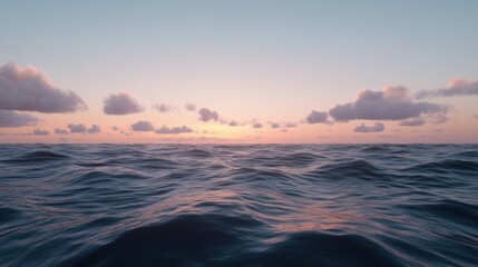 Obraz premium Serene ocean view at sunset with gentle waves and soft clouds in the sky.