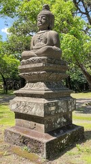 Fototapeta premium Ancient stone Buddha statue surrounded by lush greenery in a tranquil park setting