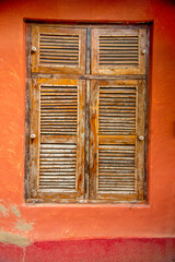 White and grey round window over orange wall