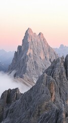Obraz premium Close-up view of Dolomites peak at golden hour with fog and soft pink sky