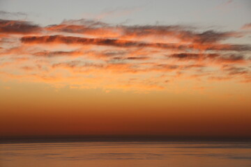 Naklejka premium couché de soleil sur l'océan, ciel coloré