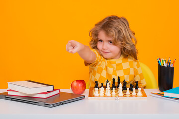 Child play chess on isolated background. Kid thinking about chess. The concept of learning and growing children. Chess, success and winning. Board logic game, kids hobby and lifestyle.