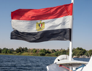 View of the Egyptian flag waving from a boat sailing on the great Nile River Egypt
