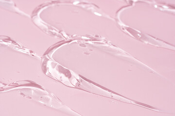 Transparent gel smears smudges swatches textures on pink background