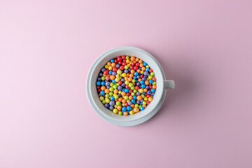 Celebration background with white cup and colorful confetti. Minimal party concept.