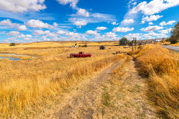 A small roadside cattle ranch with home, small barn and pond, with the 1915 Railroad Bridge in view, at Autumn in the Palouse region of Rosalia, Washington State. © Kirk Fisher