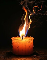 A burning small candle stub with a small bright flame, illuminating a dark black background around
