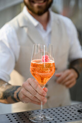 Close shot of glass with sparkling wine in the bartender's hands