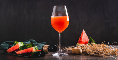 Delicious watermelon wine in a glass and watermelon pieces on a plate web banner