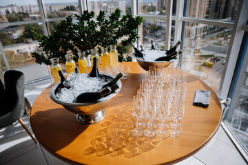 Elegant table setup with champagne bottles, ice and fresh lemonade pitchers for event or celebration