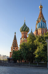 St. Basil's Cathedral. Trees, cobbled street. Blue cloudless sky. Moscow. Red Square. A famous monument in the center of the Russian capital.