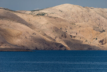 Rocky coastline of Rab Island in Croatia. Cliffs and blue Adriatic Sea.
