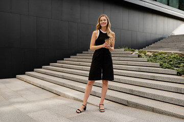 young pretty blond woman walkingoutside in street doing business