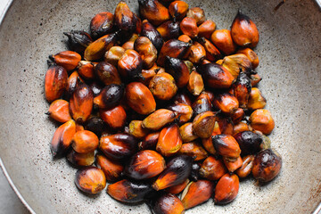 Overhead view of fresh palm nuts in a pot, top view of palm nuts for making palm oil, process of making palm oil