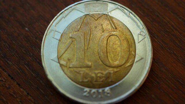 Close up of a 10 lei mdl coin on a wooden surface