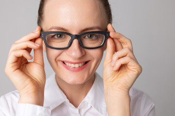 A woman puts on glasses for good vision and smiles because she can see better, good vision
