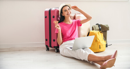 Woman with laptop booking tickets online at home