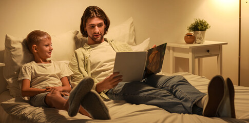 Father and his little son reading bedtime story at home